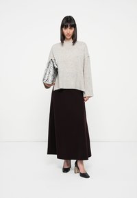 Grey knitted sweater, floor-length burgundy skirt, black high-heeled shoes, and a metallic silver snakeskin clutch. Simple design.