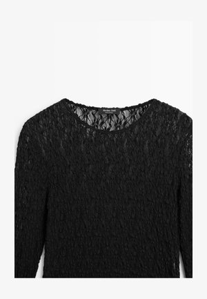 Černý krajkový top s dlouhým rukávem a kulatým výstřihem, zdobený květinovým vzorem, s texturovaným povrchem a štítkem s logem na krku.