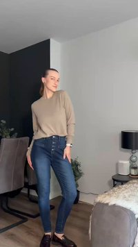 Farkut siniset slim fit -tyyliset, korkea vyötärö, jossa nappisulku ja ommeltu yksityiskohtia. Yhdistetty vaaleanbeigeen pitkähiharaiseen paitaan.