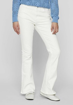 Vaqueros de mezclilla blanca acampanados con una cintura alta. Fabricados con un tejido texturizado, cuentan con cinco bolsillos y detalles de costura visibles.