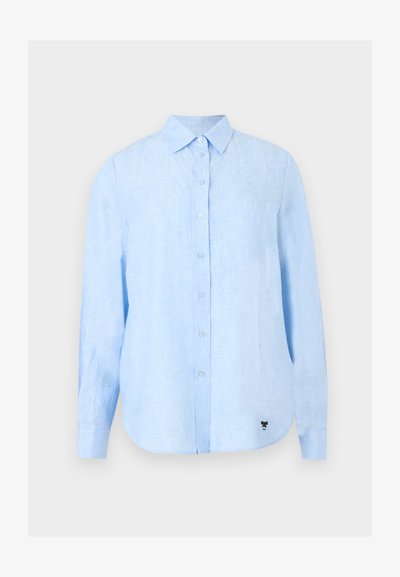 Chemise bleu clair à manches longues avec col, en tissu texturé, avec un petit logo noir près de l'ourlet inférieur.