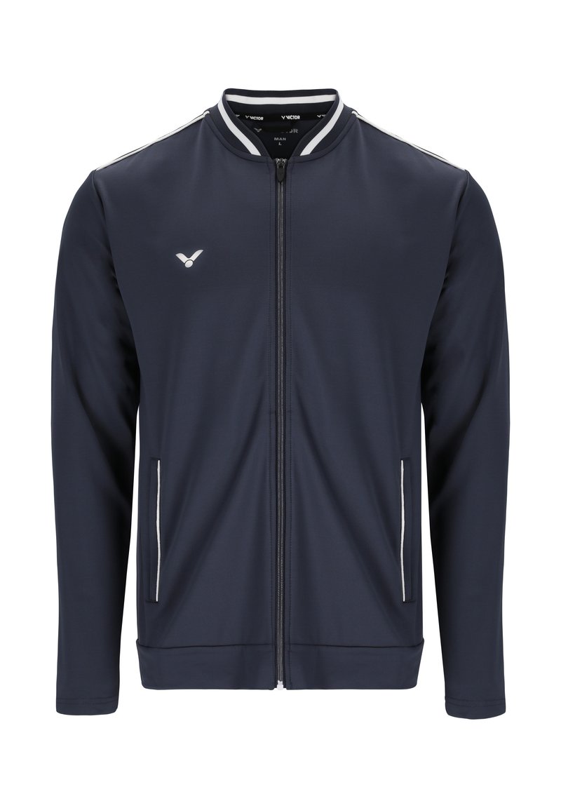 Marineblå sportsjakke med fuld lynlås, lange ærmer, hvide accentstriber, sidelommer og logo på venstre bryst. Glat stofstruktur.