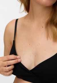 Sort stoff-bh med tynne stropper, V-formet design. Jevn tekstur, minimale dekorasjoner, som viser en enkel og funksjonell stil.