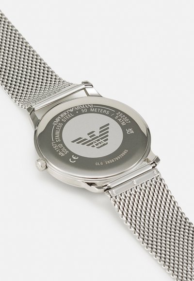 Silberner Edelstahluhren mit einem Mesh-Armband, das ein rundes Gehäuse und gravierte Rückendetails aufweist. Wasserdicht bis zu 50 Metern.