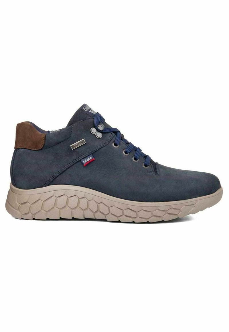 Chaussures mi-hautes étanches bleu marine avec semelle en caoutchouc beige texturée hexagonale, accent en daim marron au talon et lacets bleus. Présente un logo sur la languette.