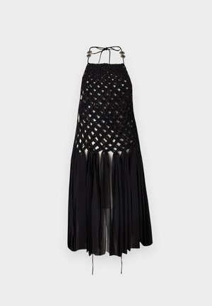 Robe noire à col halter avec partie supérieure en treillis tissé et jupe fluide plissée et transparente, bretelles nouées avec ornements métalliques.