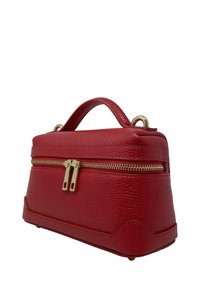 Czerwona skórzana torebka o strukturalnym kształcie, z górnym uchwytem i złotym zamkiem błyskawicznym. Teksturowana powierzchnia oraz podwójne zamknięcie na zamek.