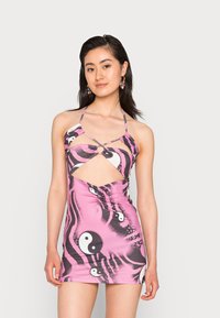 Vestido mini rosa, estampado, com um design recortado e alças halter. Apresenta um destacável circular na zona do peito e um tecido suave e elástico.