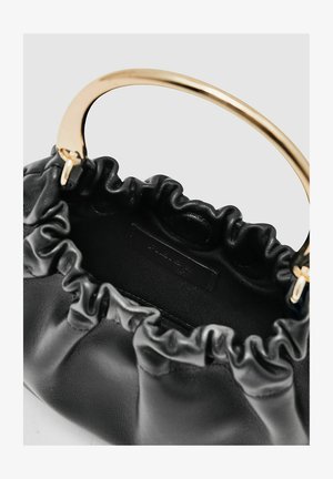 Melnas ādas rokassoma ar zeltītiem metāla rokturiem. Dizains ietver rūtētu atvērumu un teksturētu iekšpusi, piedāvājot kompaktu formu.