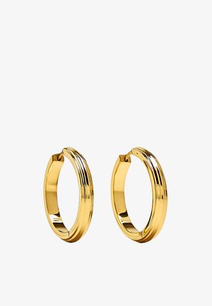 Para gładkich, polerowanych złotych kolczyków-kołeczków z delikatnym żłobieniem na zewnętrznej powierzchni, ustawionych na białym tle.