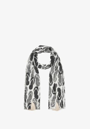 Écharpe noire et blanche avec des motifs abstraits de feuilles et de rayures, présentant des bords effilochés et deux pompons beiges aux extrémités.