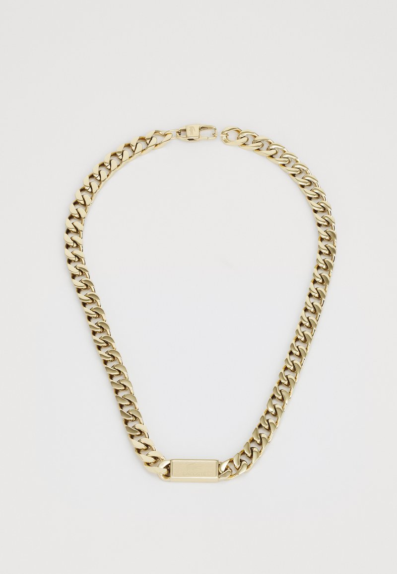 Gouden ketting met een dik interlock schakeldesign, voorzien van een platte rechthoekige sluiting en een klein gegraveerd logo op de hardware.
