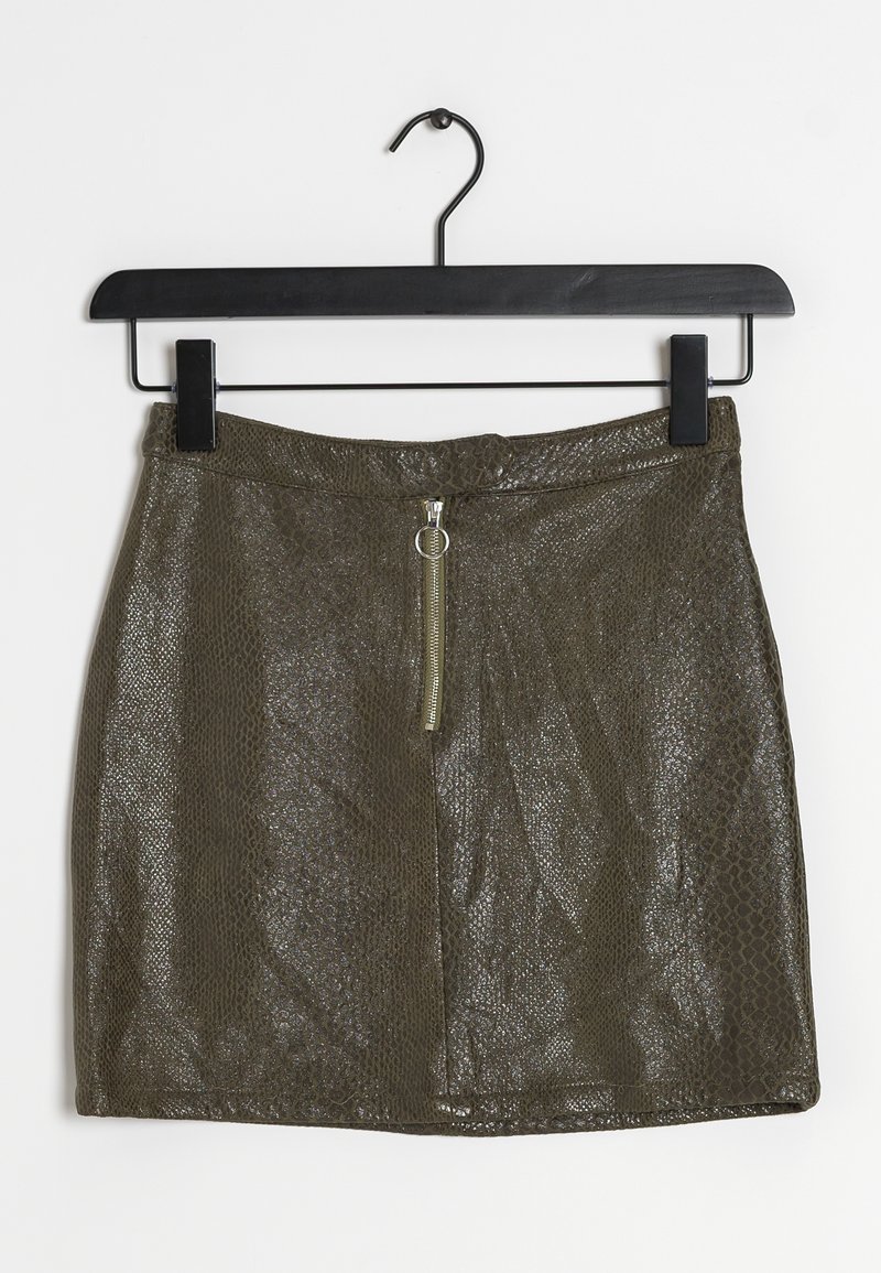 Olivově zelená mini sukně s texturou hadího vzoru, s předním zipem a detailem s kroužkem, zavěšená na černém ramínku.