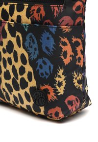 Juodas nailono krepšys su spalvingu leopardų ir kaukolių raštu, turintis tekstūruotą paviršių ir apvalų logotipą.