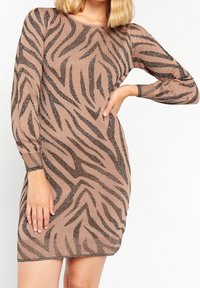 Abito lavorato a maglia marrone con stampa zebra nera e dettagli metallici. Presenta maniche lunghe e una silhouette aderente, con polsini a coste.