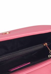 Borsa a tracolla in faux leather rosa con chiusura magnetica. L'interno presenta una fodera nera, un compartimento con zip e una linguetta di accentuazione rosa.