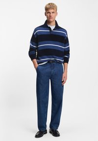 Navy striped sweater with a collar, paired with loose dark denim jeans and black shoes. Casual ensemble, flat knit texture, relaxed fit.