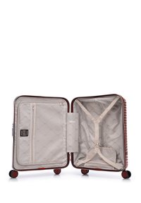 Harde koffer in donkerrood met een ribbelachtige buitenkant. Het interieur heeft een beige voering, een ritsvak en elastische straps om spullen te beveiligen.