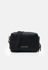 Bolso bandolera de cuero negro con acabado texturizado, herrajes dorados y una correa de marca que presenta la palabra "VALENTINO" en letras negritas.