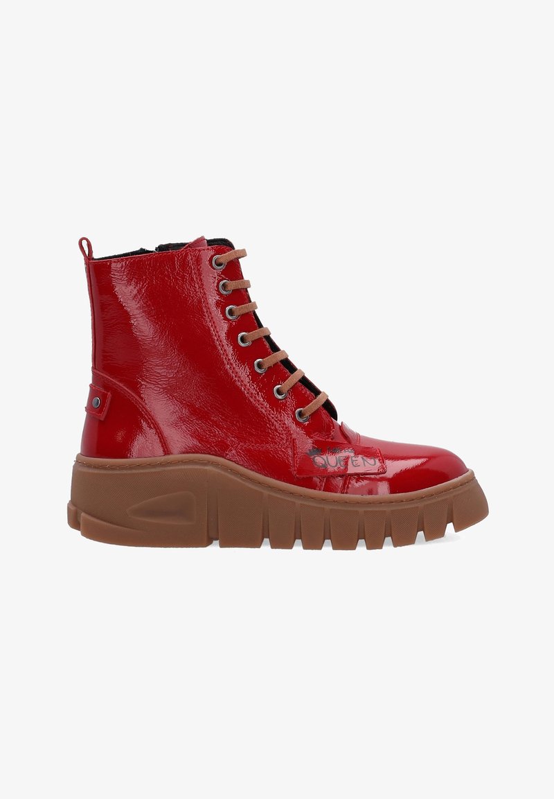 Bottine à lacets en cuir verni rouge brillant avec semelle épaisse marron rainurée et languette à l'arrière du talon.