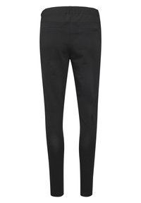 Leggings noirs avec une taille élastique, présentant une texture lisse et deux poches arrière. Le design est ajusté, se rétrécissant aux chevilles.