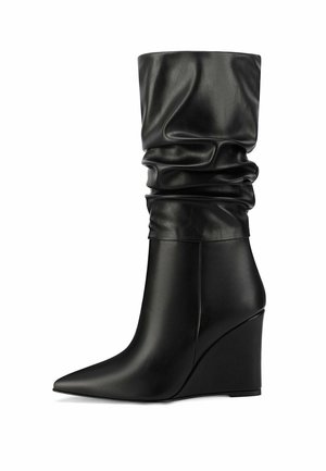 Stivali con tacco a zeppa in pelle nera, con un gambale morbido e punta affusolata, caratterizzati da una superficie liscia e un design elegante e strutturato.