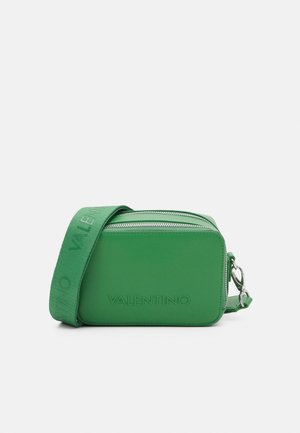 Sac bandoulière vert de forme rectangulaire, fabriqué en cuir lisse, avec une fermeture éclair et un logo embossé sur le devant.