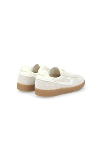 Zapatillas de ante crema con un swoosh de cuero blanco, parte superior texturizada, puntera redonda y suela de goma. El logo en el talón es visible.