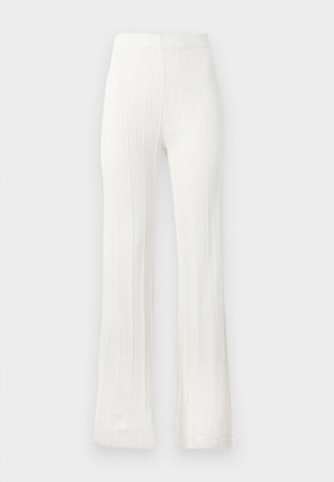 Kraťasy bílé barvy, rozšířené ve spodní části, vyrobené z texturované tkaniny s vertikálním žebrováním. Elastický pas, bez viditelných zapínání nebo kapes.