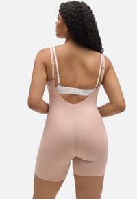 Corpiño modelador nude con espalda en V profunda, tirantes ajustables y longitud hasta medio muslo. Fabricado con una tela suave y elástica para un ajuste ceñido.