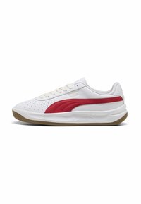 Sneaker bianche con tomaia in pelle perforata, dettagli rossi, lacci piatti, suola imbottita e suola in gomma testurizzata. Presenta il logo Puma sul lato.