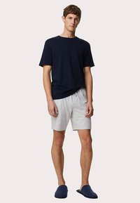 Marineblaues T-Shirt, hellgraue Shorts, blaue Slip-On-Schuhe. Lässige Passform, weicher Stoff, kurze Ärmel, elastischer Bund, minimalistisches Design.