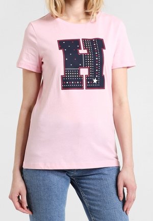 T-shirt en coton rose avec un graphique « H » bleu marine ornée de motifs d'étoiles et d'accents en strass sur le devant. Manches courtes et décolleté arrondi.