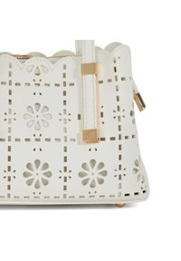 Weißes Lederhandtasche mit durchbrochenen Blumenmustern, gewelltem oberen Rand, goldenen Hardware-Details und einer strukturierten Form.