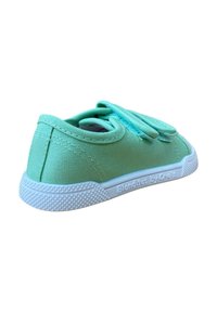 Zapato de lona verde menta con punta redonda, suela de goma blanca y agarre texturizado. Presenta un diseño de cordones con cordones a juego.