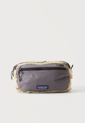 Kompakt beige og grå Patagonia bæltetaske med lynlåslomme foran og synligt logomærke centreret under lynlåsen.
