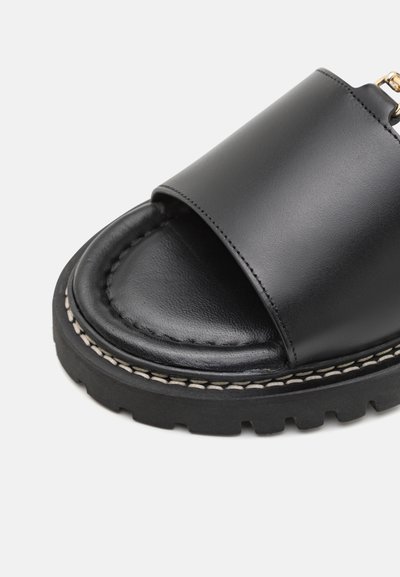 Černé kožené skluzavkové sandály s širokým horním pásem, polstrovanou stélkou a masivní gumovou podrážkou se viditelnými švy.