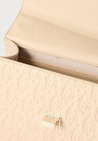 Μπεζ πορτοφόλι με υφή και ανάγλυφο επαναλαμβανόμενο μοτίβο "S", ανοιχτό καπάκι και λαμπερό χρυσό ορθογώνιο κούμπωμα στο μπροστινό μέρος.