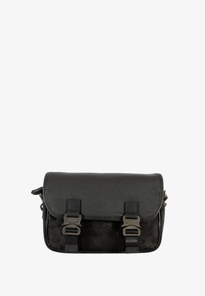 Sac cartable noir avec rabat en cuir, deux fermetures à boucle métallique, sangles latérales réglables et motif circulaire embossé sur le corps.