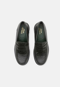 Schwarze Leder-Loafer mit Krokodilmuster, ausgestattet mit einer glatten Oberseite und kontrastierenden grünen Einlegesohlen. Runde Zehenform und minimalistisches Design.