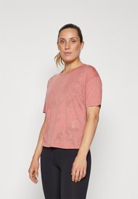 Short-sleeve, relaxed-fit t-shirt in dusty rose color. Made of soft fabric with a subtle pattern, featuring a round neckline and cropped hem.