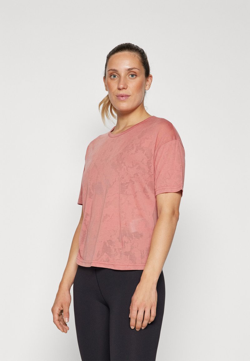 Short-sleeve, relaxed-fit t-shirt in dusty rose color. Made of soft fabric with a subtle pattern, featuring a round neckline and cropped hem.