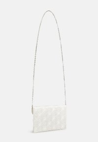 Bílá kabelka se vzorem ve tvaru mušle, vyrobená z texturované látky. Má stříbrný řetízek a obdélníkový tvar.