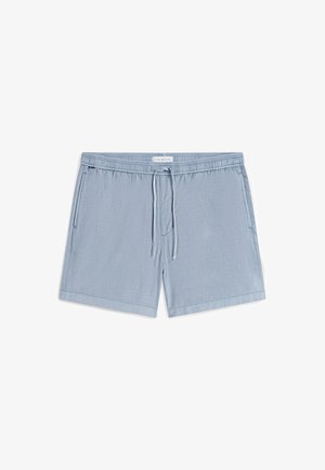 Short de bain homme bleu clair avec taille élastique, cordon de serrage, poches latérales et étiquette Tommy Hilfiger au centre de la ceinture à l’avant.