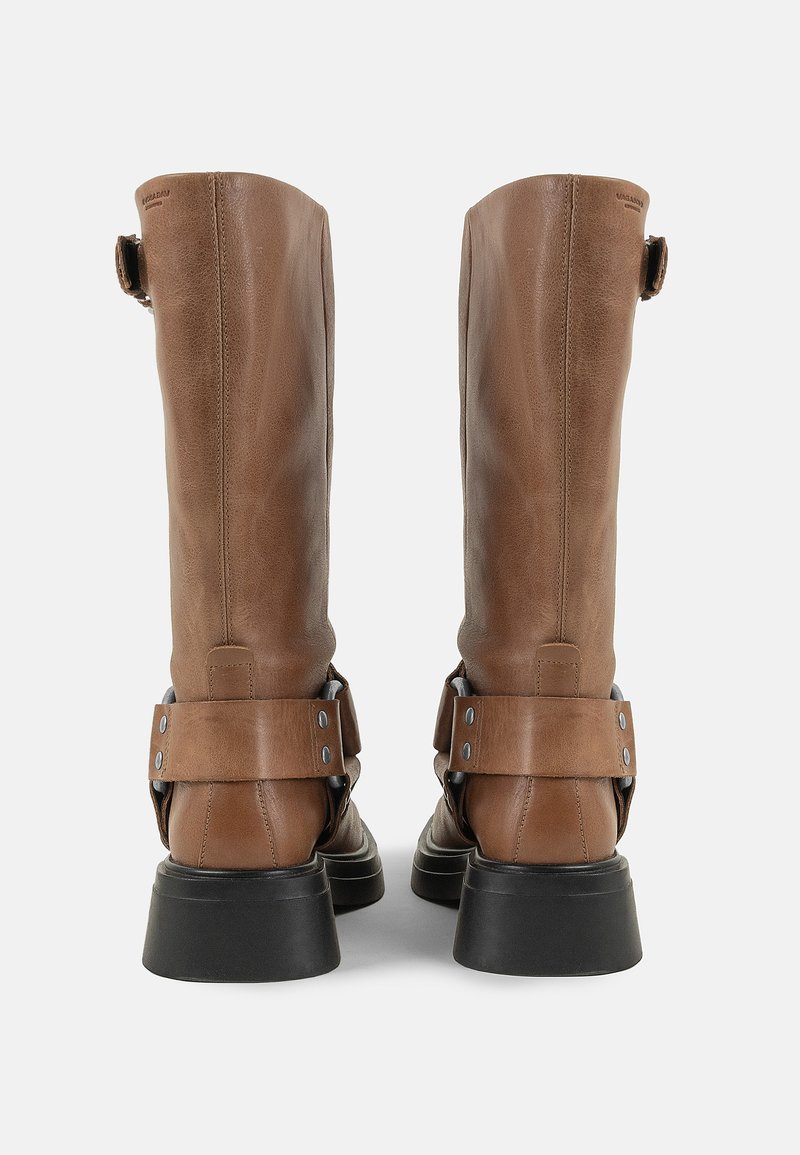 Botas de cuero marrón hasta la rodilla con una textura suave, con correas ajustables y una suela de goma negra resistente.