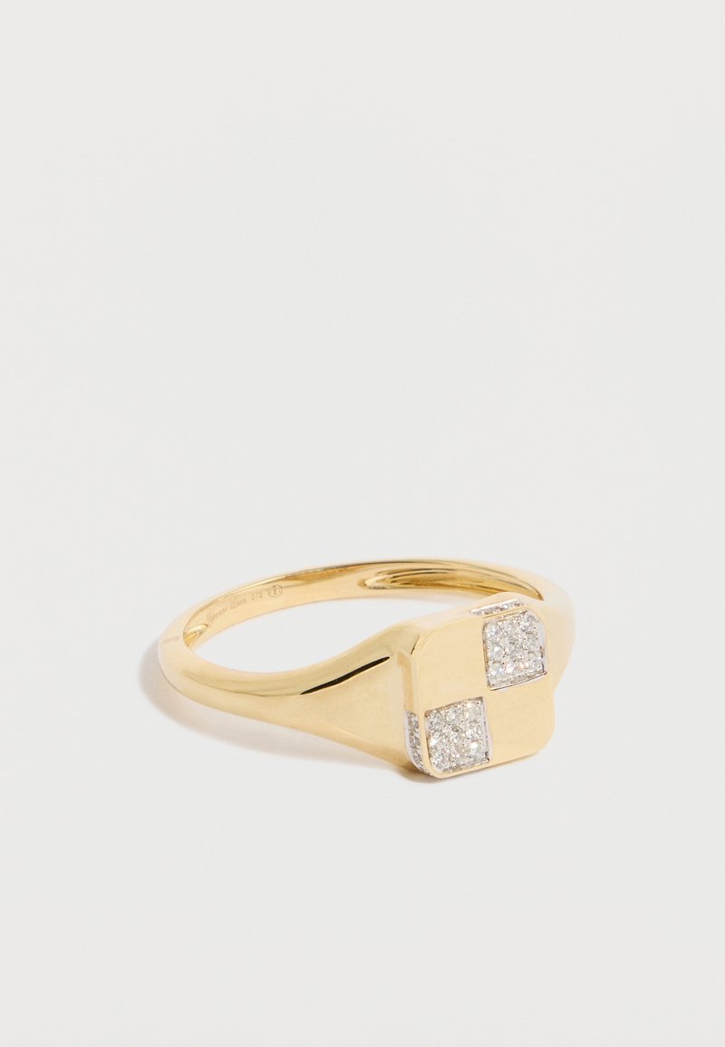 Arany gyűrű, sima gyűrűszalaggal, négyzet alakú tetővel, amely két apró, csillogó gyémántot díszít, matt felülettel.