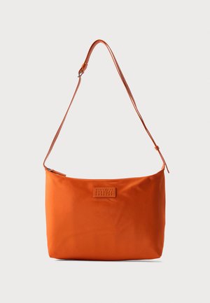 Orangene Schultertasche mit verstellbarem Riemen und rechteckigem, aufgenähtem Logoaufnäher auf glatter Stoffoberfläche.
