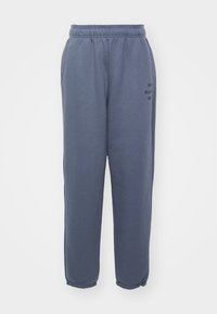 Pantalones de chándal azules hechos de una tela suave, con una cinturilla elástica, tobillos ajustados y detalle de logotipo impreso en la pierna izquierda.