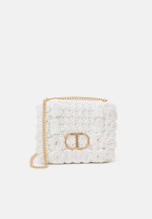 Hvid flettet taske med tekstureret overflade, gyldent kæderem og central spænde med dekorativt logo. Kompakt design med blomsterdetaljer.