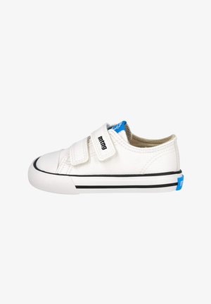 Zapatilla blanca de caña baja con dos correas de velcro, rayas laterales negras y logotipo de la marca azul en la lengüeta y la pestaña del talón.